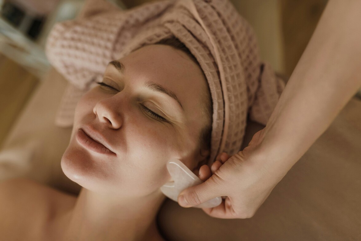 A woman receiving gua sha treatment on her face